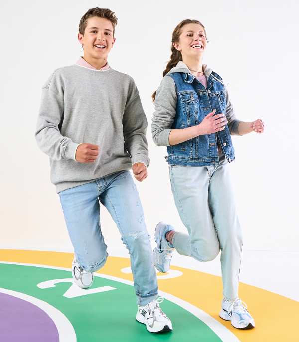 Teenage boy and a girl are running wearing athletic sneakers