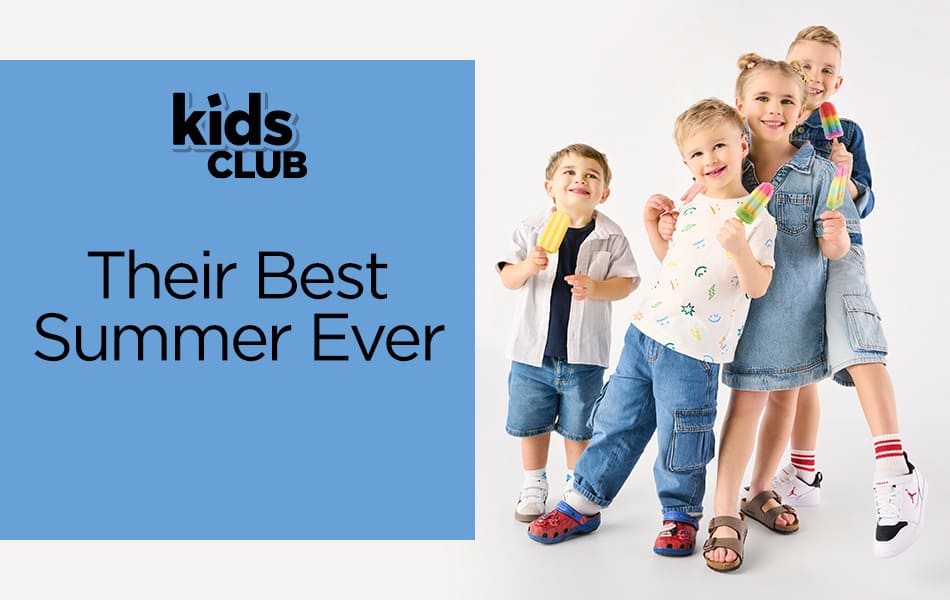 A group of four siblings standing from left to right, shortest to tallest eating popsicles and enjoying family time while wearing a variety of comfortable kids footwear.