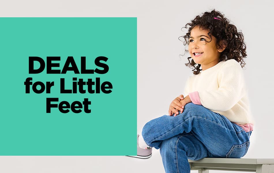 A little girl wearing pink converse sitting on a bench and smiling upwards.